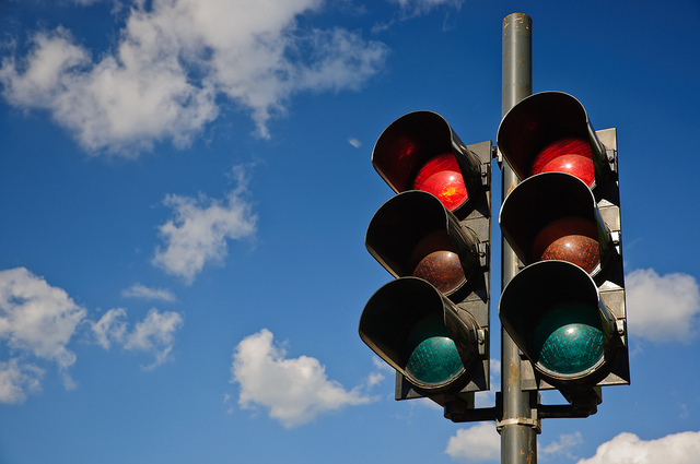 A couple of red traffic lights against a blue sky